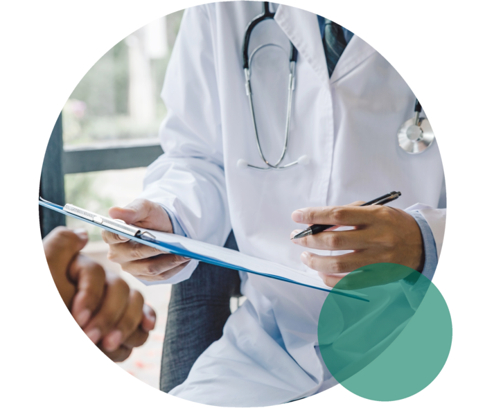 Hypercholesterinämie: Ärztliche Beratung Hände und Oberkörper eines Mannes mit weißem Kittel. Er hält ein Klemmbrett und einen Stift. Gegenüber die gefalteten Hände einer weiteren Person.